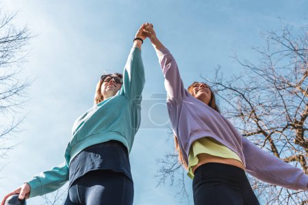 Photo for Couple of female athletes having fun while climbing on sport metal structure outdoors - wellness concept - Royalty Free Image