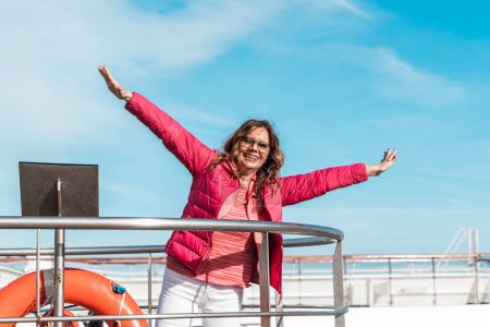 Téléchargez les photos : Belle femme d'âge moyen heureux s'amuser sur le pont d'un bateau de croisière - Voyage et vacances concept - en image libre de droit