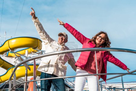 Foto de Hermosa pareja de mediana edad feliz divirtiéndose en la cubierta de un crucero - viaje y concepto de vacaciones - Imagen libre de derechos