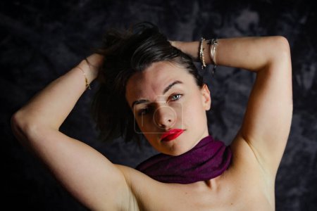 Téléchargez les photos : Portrait de jeune belle femme s'amuse avec une écharpe rouge - plan studio - en image libre de droit