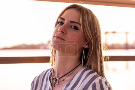 Téléchargez les photos : Portrait d'une jeune belle femme assise sur un bateau naviguant pendant les vacances d'été sur une rivière - en image libre de droit