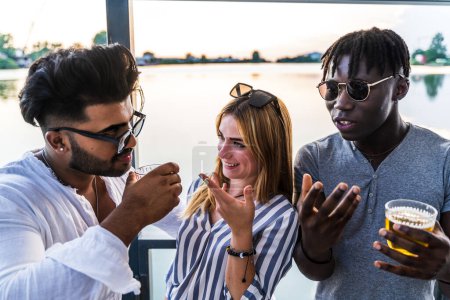 Photo for Small group of young adult multiethnic friends celebrating toasting with alcohol - summer vacation concept on a ship on the river - Royalty Free Image