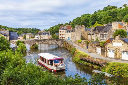 Photo for Panoramic view of old stone bridge and historical medieval houses reflecting in La Rance river in Dinan town - tourist boat in navigation - Royalty Free Image