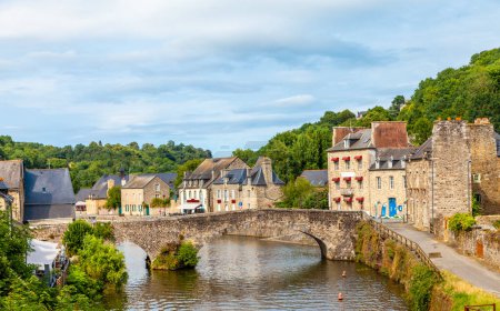 Foto de Vista panorámica del viejo puente de piedra y casas medievales históricas que reflejan en el río La Rance en el puerto de Dinan ciudad Bretaña Francia - Imagen libre de derechos