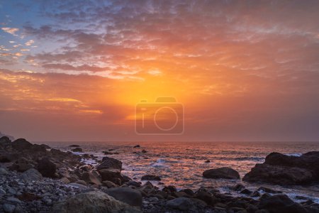 Photo for Fiery summer sunset behind the typical rocks of benijio beach in the north east of tenerife island - travel concept - Royalty Free Image