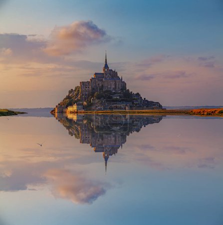 Foto de Vista panorámica de la famosa abadía de Le Mont Saint-Michel reflejada en la marea alta al atardecer, Normandía, Francia - Imagen libre de derechos