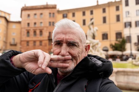 Téléchargez les photos : Heureux homme d'âge moyen en vacances prendre un selfie en face de la fontaine de la place Navona à Rome - concept amusant et vacances. - en image libre de droit