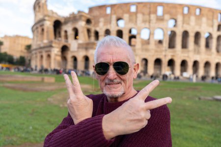 Photo for Happy middle aged man on vacation taking a selfie in front of coliseum amphitheatre in rome - fun and vacation concept. - Royalty Free Image