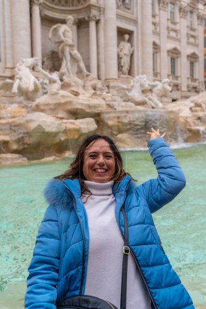 Photo for Happy middle aged female tourist on vacation throwing a coin in the water of famous trevi fountain in rome - fun and vacation concept - Royalty Free Image