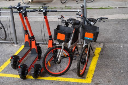 Photo for Electric scooter and electric bicycle rental subscription service in urban parking in city - eco sustainable urban transport concept - Royalty Free Image
