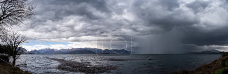 Photo for Panorama of lake Maggiore on a rainy day with heavy low clouds covering part of the coast - travel and vacation concept - Royalty Free Image