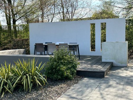 Foto de Appeltern, Países Bajos, 09 de abril de 2023: El parque de inspiración del jardín para toda la familia. Moderna terraza jardín con paredes y muebles. Plataforma de madera - Imagen libre de derechos