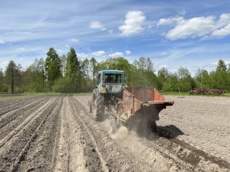 Foto de Plantación mecanizada de patatas. Tractor con sembradora de patatas en el campo. - Imagen libre de derechos
