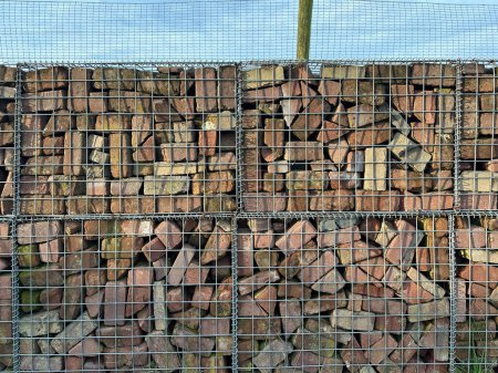 Gabionen-Stützmauer mit Ziegeln gefüllt