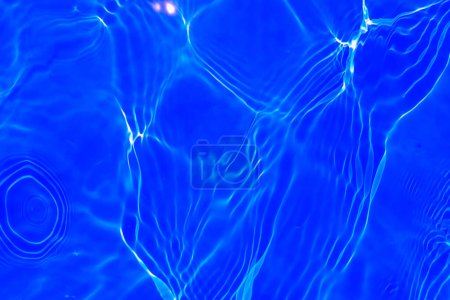 Photo for Defocus blurred transparent blue colored clear calm water surface texture with splashes and bubbles. Trendy abstract nature background. Water waves in sunlight with copy space. Blue watercolor shining - Royalty Free Image
