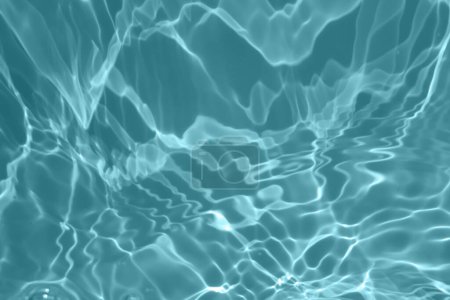Defocus verschwommen transparent blau gefärbt klare ruhige Wasseroberfläche Textur mit Spritzern und Blasen. Trendige abstrakte Natur Hintergrund. Wasserwellen im Sonnenlicht mit Kopierraum. Blaues Aquarell leuchtet