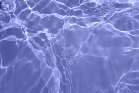 Defocus verschwommen transparent blau gefärbt klare ruhige Wasseroberfläche Textur mit Spritzern und Blasen. Trendige abstrakte Natur Hintergrund. Wasserwellen im Sonnenlicht mit Kopierraum. Blaues Aquarell leuchtet
