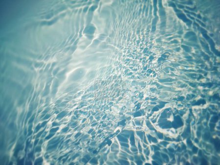 Photo for Defocus blurred transparent blue colored clear calm water surface texture with splashes and bubbles. Trendy abstract nature background. Water waves in sunlight with caustics. Blue water shinning - Royalty Free Image