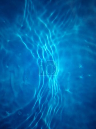 Photo for Defocus blurred transparent blue colored clear calm water surface texture with splashes and bubbles. Trendy abstract nature background. Water waves in sunlight with caustics. Blue water shinning - Royalty Free Image