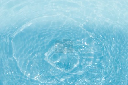 Défocus flou transparent bleu clair texture de surface de l'eau calme avec éclaboussures et bulles. Fond nature abstrait à la mode. Vagues d'eau en plein soleil avec causalité. Shinning d'eau bleue 