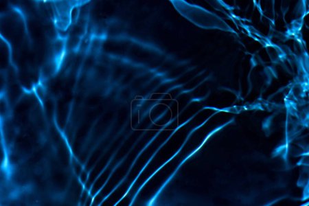 Téléchargez les photos : Ondes d'eau bleue sur les ondulations de surface floues. Défocus flou transparent bleu clair texture de surface de l'eau calme avec éclaboussures et bulles. vagues d'eau avec motif brillant texture fond. - en image libre de droit