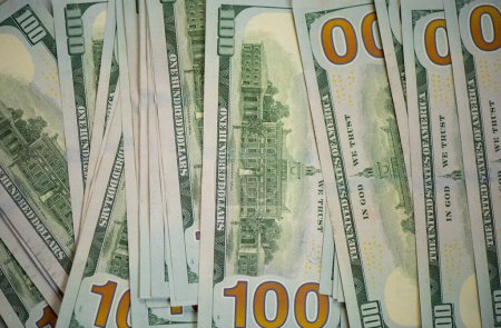 Hundert-Dollar-Scheine. Stapel von hundert US-Banknoten. Hintergrund sind amerikanische Hundert-Dollar-Scheine. 100 Scheine im Hintergrund. Jede Menge Dollar. Briefmarke mit US-Dollar und Euro
