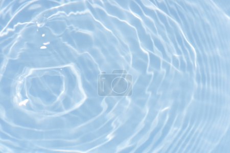 Ondas de aguas azules en la superficie se difuminan. Desenfoque borrosa transparente de color azul claro textura de la superficie del agua calma con salpicaduras y burbujas. Ondas de agua con brillante patrón de textura de fondo.