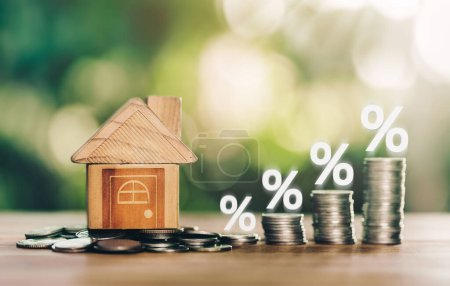 Haus und Münzen auf dem Holztisch ist Leiter mit weißer Abbildung zeigt sinkende Zinsen. Planung Spargeld von Münzen, um ein Eigenheimkonzept für Immobilie Leiter kaufen, Hypothek.