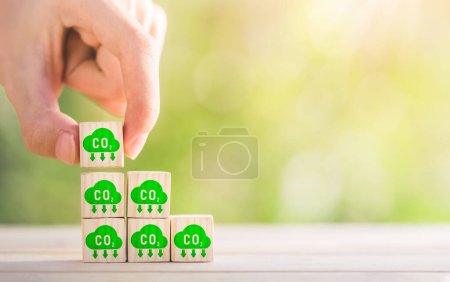 CO2 emission concept. Green industries business concept. Net zero emissions. Renewable energy, sustainable technology, ecology solutions. Hand puts the wooden cubes with CO2 emission reduction icon.