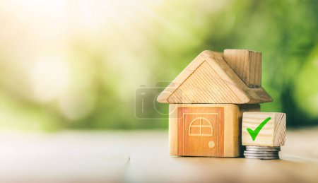 Mortgage and loan approved concept, house is placed on a wooden block with an approval mark or a check mark. Mortgage rates business concept of investment real estate. Home Mortgage Loan Approval.