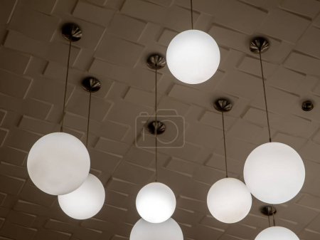 Foto de Round lamp, hanging alternating high and low, decorating the ceiling - Imagen libre de derechos