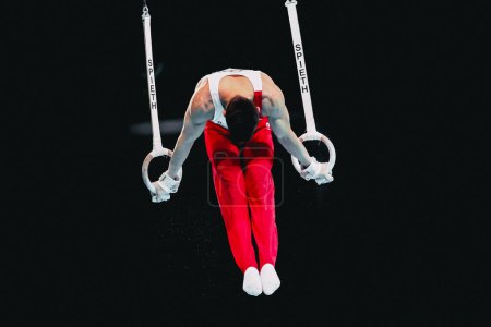 Photo for Szczecin, Poland, April 10, 2019:olympic male Belarusian athlete Sanuvonh Dzianis competes on the rings during the artistic gymnastics championships - Royalty Free Image