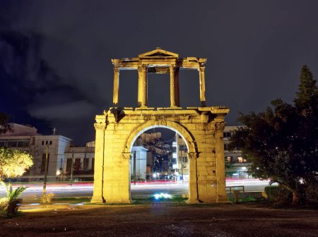 Téléchargez les photos : Night view of Hadrian Arch Temple of Olympian Zeus. Light trails of moving cars appear behind. Athens, Greece - en image libre de droit