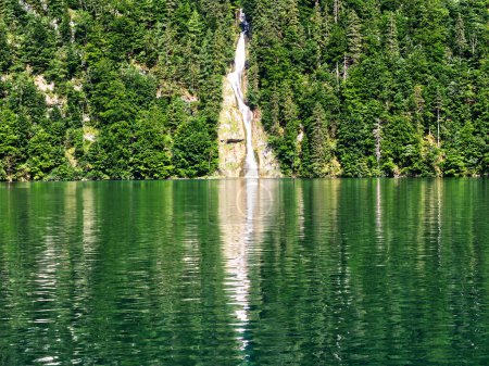 Téléchargez les photos : Cascade tombant dans le lac. Réflexions sont faites dans les eaux propres du lac. Paysage Konigssee en Bavière, Allemagne - en image libre de droit