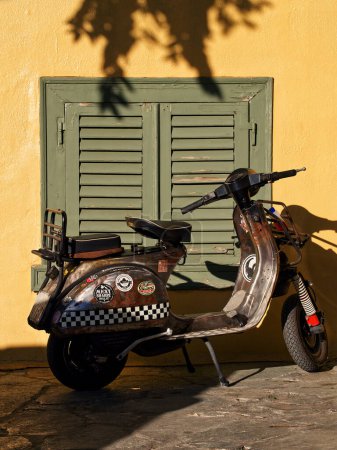 Photo for Scooter parked in street in front of yellow traditional building wall. High quality photo - Royalty Free Image