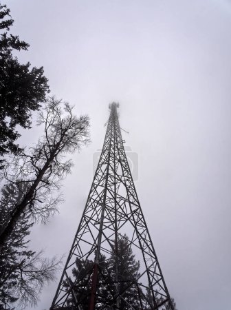 Vue à faible angle de la tour radio perdue dans le brouillard. Photo de haute qualité