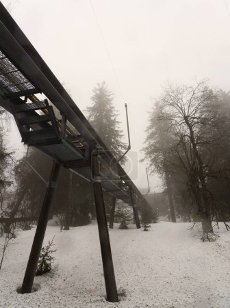 Weitwinkelblick auf die Schwebebahnbrücke im schneebedeckten Wald 