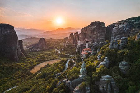 Aerial view of monasteries Trinity and breathtaking pictures of valley and landmark canyon of Meteora at sunset, Kalambaka, Greece, shadows, twisted road, bridge, Mountains as columns