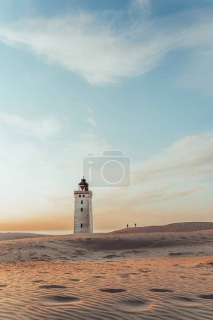 Photo for Minimalistic photo of people at sunset Rubjerg Knude Lighthouse Denmark. High quality photo - Royalty Free Image