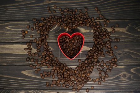 Foto de Fragrant rich coffee beans of different varieties on a dark wooden surface are laid out in the form of a cat. for banners, flyers, splash screens, menu labels - Imagen libre de derechos