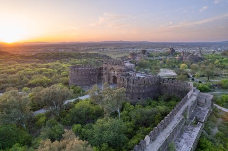 Beautiful landscape of Rohtas fort on top of green hills during sunset which shows ancient Indian and Mughal history, heritage and vintage architecture.
