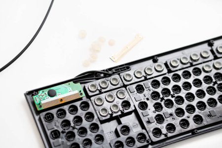 Photo for Repair, cleaning the keyboard. disassembled black keyboard, rubber white caps, microcircuit. keyboard details. - Royalty Free Image