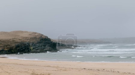 Nuages de pluie foncés alors que la tempête frappe Eoropie Beach sur l'île de Lewis. Météo typiquement écossaise lors d'une journée gris humide sur la côte des Hébrides extérieures.