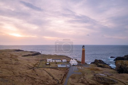 Aerial view of sunset and lilac sky over Butt of Lewis Lighthouse in the Outer Hebrides of Scotland.