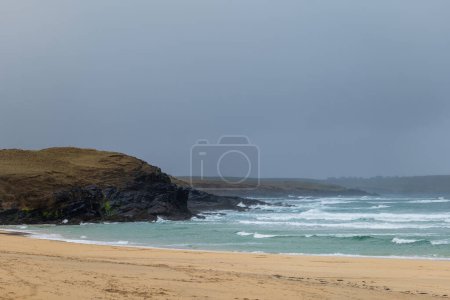 Waves crash onto empty Eoropie Beach on the Isle of Lewis, Scotland with bad weather.