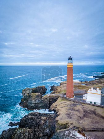 Photo for Aerial view of sunset and lilac sky over Butt of Lewis Lighthouse in the Outer Hebrides of Scotland. - Royalty Free Image