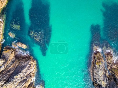 Drohnenaufnahme von Port of Stoth auf der Insel Lewis. Türkisfarbenes Wasser umgeben von Felsen und Klippen der umliegenden Bucht auf den Äußeren Hebriden