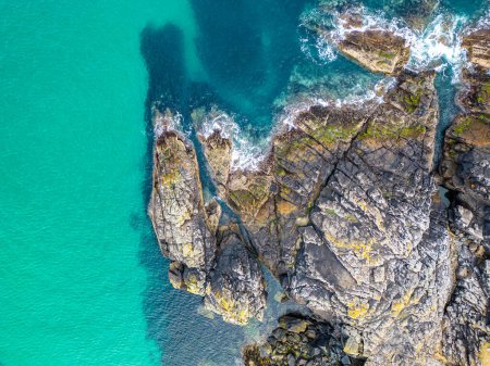 Drohnenaufnahme von Port of Stoth auf der Insel Lewis. Türkisfarbenes Wasser umgeben von Felsen und Klippen der umliegenden Bucht auf den Äußeren Hebriden
