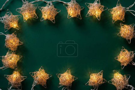 Photo for Christmas winter festive ornament. Christmas lights frame on green background. Invitation Christmas holiday party. Flat lay, top view, copy space. - Royalty Free Image