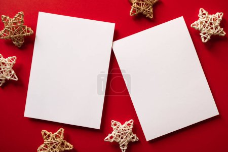 Photo for Christmas winter festive ornament. Blank paper cards with wooden decoration on red background. Minimal decoration. Invitation Christmas holiday party. Flat lay, top view, copy space. - Royalty Free Image